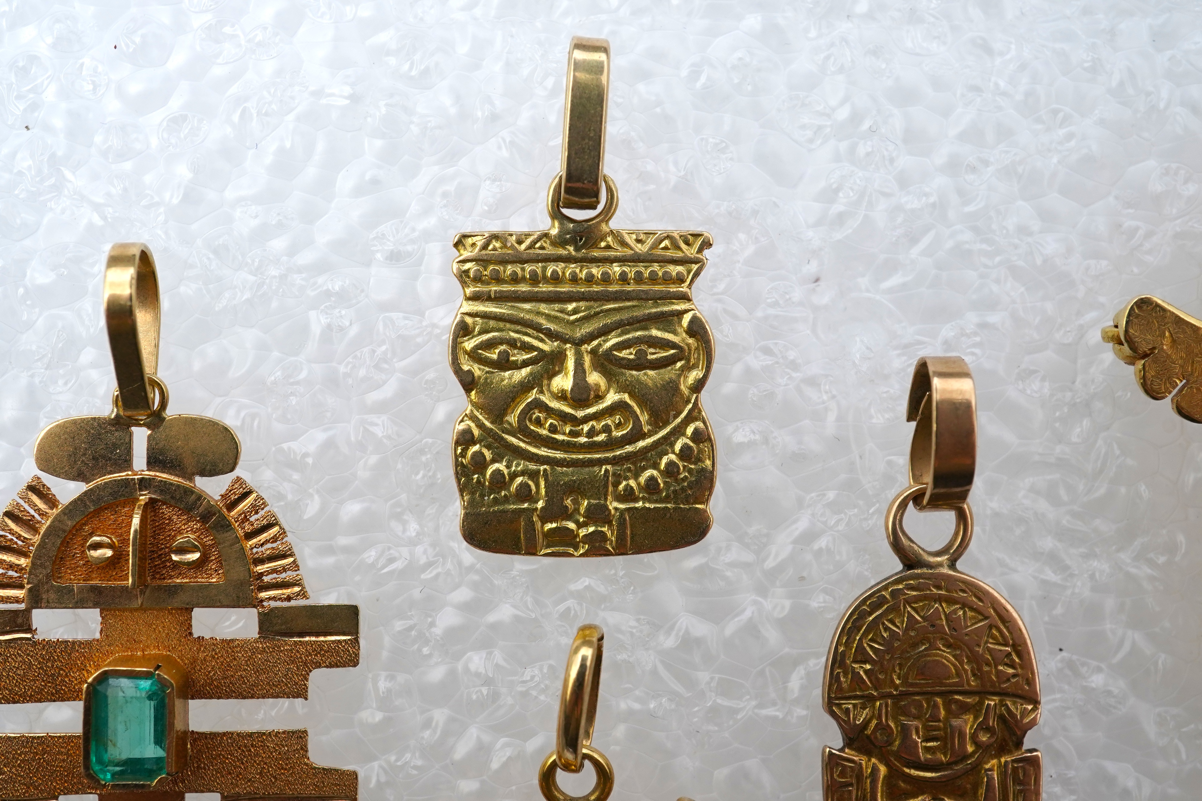 A collection of five gold pendants